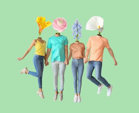 Jumping young friends with flowers instead of their heads on green background