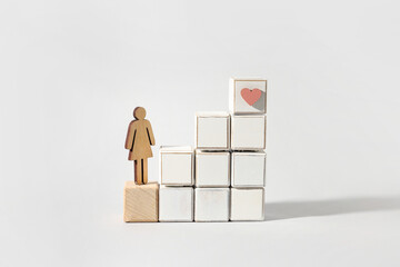 Female silhouette and ladder made of wooden blocks on light background