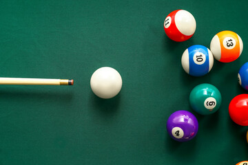 Colorful billiard balls with cue on table - obrazy, fototapety, plakaty