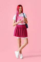 Young female student with bright unusual hair and coffee on pink background