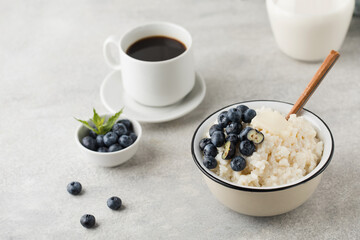 Rice milk porridge with blueberries and a mug of black coffee. Healthy breakfast.