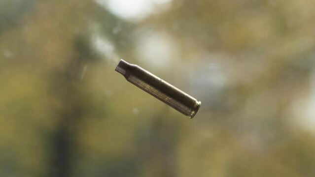 Used firearms cartridge 5,56 x 45  with smoke in flight after shot.