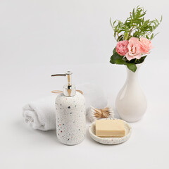 Bath accessories and vase with flowers on white background