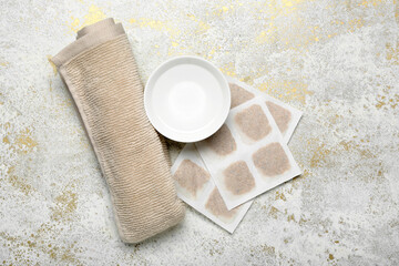 Mustard plasters with bowl of water and towel on grunge background