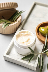 Jar of natural olive cream on white background, closeup