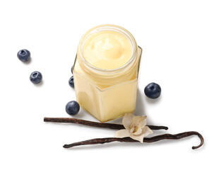 Glass jar of delicious pudding, vanilla sticks and blueberry on white background