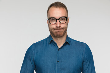 young casual man is puffing cheeks