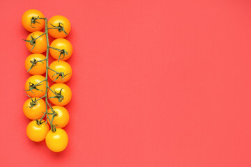 Branch of ripe yellow tomatoes on red background