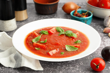 Plate of tasty tomato soup on grunge background, closeup