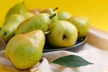 Plate of tasty ripe pears on yellow background, closeup