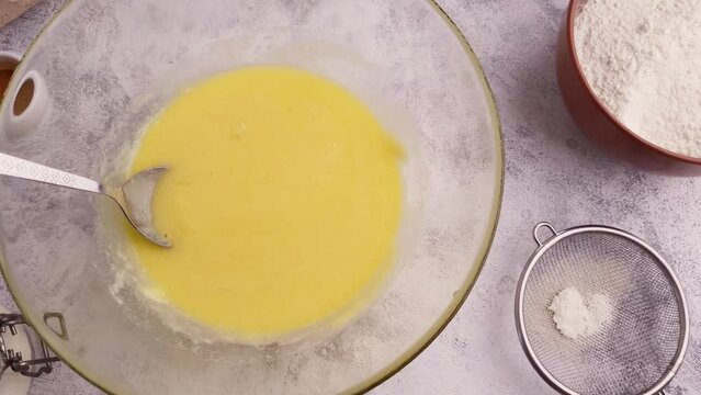 Smooth motion over table with baking ingredients and yellow dough in a plate
