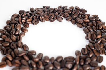 Roasted coffee Beans on white background. Coffee beans close up. Coffee grounds. Freshly roasted coffee beans. Image of a drink made from granules, derived from coffee plant. Copy space for text.