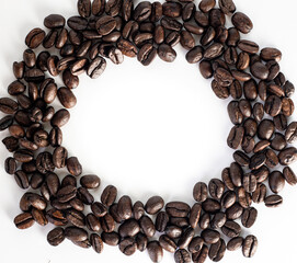 Roasted coffee Beans on white background. Coffee beans close up. Coffee grounds. Freshly roasted coffee beans. Image of a drink made from granules, derived from coffee plant. Copy space for text.
