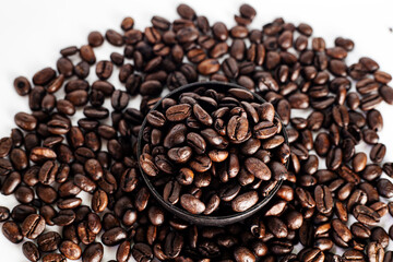 Coffee Beans on white background. close up. Coffee grounds. Freshly roasted coffee beans. Image of a drink made from granules, derived from coffee plant. Copy space for text.