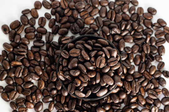 Coffee Beans on white background. close up. Coffee grounds. Freshly roasted coffee beans. Image of a drink made from granules, derived from coffee plant. Copy space for text.