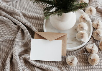 Blank greeting card, invitation mock up, craft envelope,beige knitting blanket, Christmas tree...