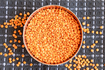 Red lentils, a raw grain inside of bowl close up , top view