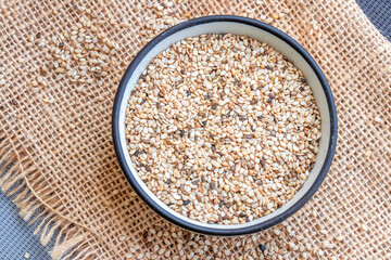 Sesame seeds inside of ceramic bowl close up, top view