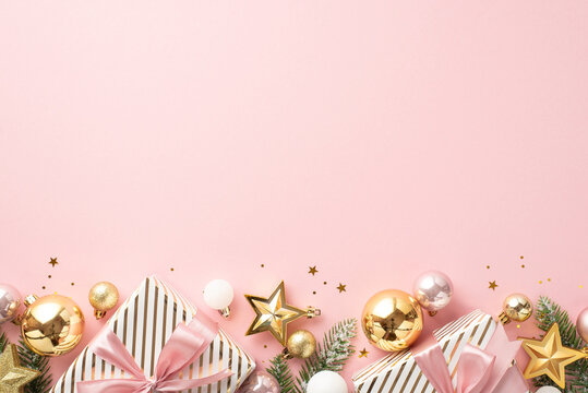 New Year concept. Top view photo of big present boxes with ribbon bows pine branches in frost gold pink baubles star ornaments and shiny confetti on isolated pastel pink background with empty space