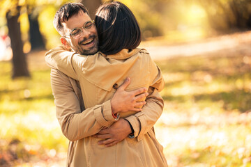 Fototapeta premium Couple in love hugging on autumn park, enjoying a beautiful autumn day.