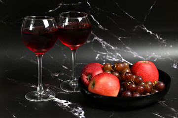 Two glasses with wine, apples and grapes 