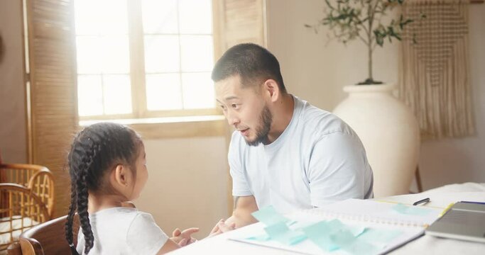 Asian bearded father talks with daughter and hugs in bedroom