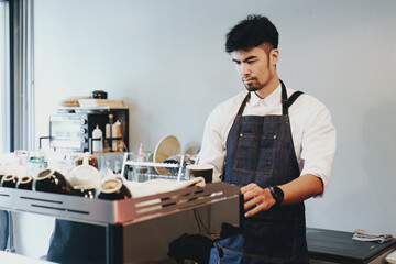 Asian male barista making coffee for customers