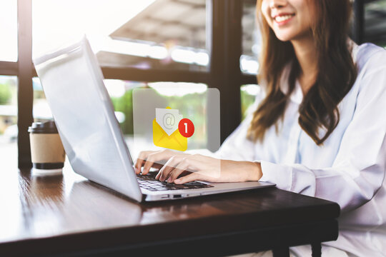 email marketing and inbox concept. Businesswoman checking e-mail on laptop with email inbox icon illustration. company sending many e-mails or digital newsletter to customers