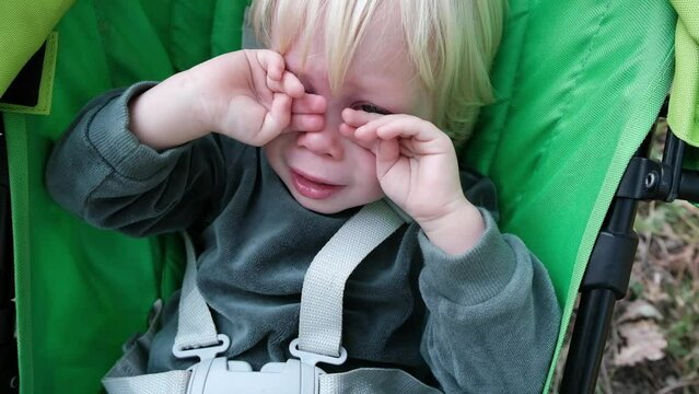 Little cute boy crying in a stroller