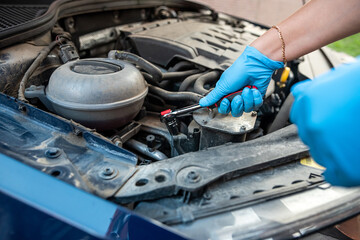 Fototapeta premium Car maintenance and service close-up technician auto mechanic repairs car engine.