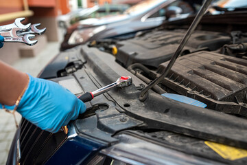 Auto mechanic works and repairs car engine in mechanics garage.