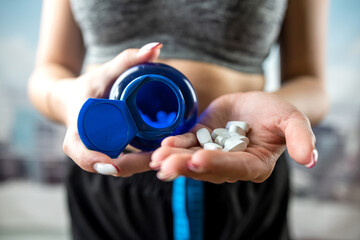 Close-up of happy smiling woman taking vitamin pills for health.