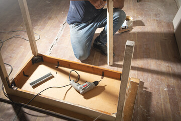 Caucasian carpenter repairing broken table.