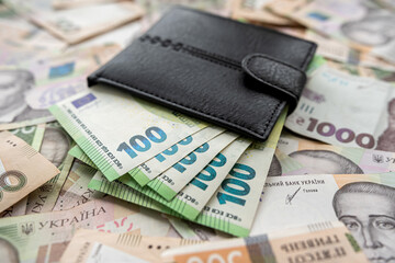 leather puse full in euro banknotes lying on ukraine money uah hryvnia, exchange concept.