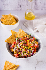 Homemade cowboy caviar traditional mexican vegetable salad and nachos in a bowl. Vertical view