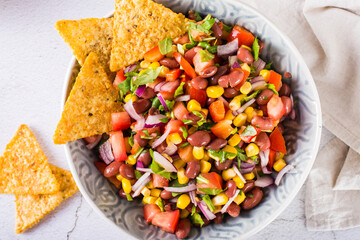 Mexican vegetable salad cowboy caviar and nachos in a bowl on the table. Top view. Closeup