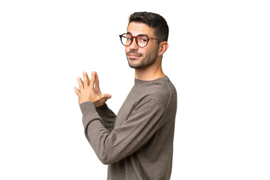 Young handsome caucasian man over isolated background scheming something