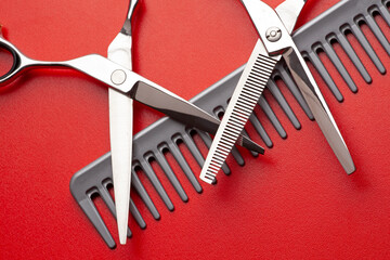 a hairdresser's tool scissors, comb on a red background