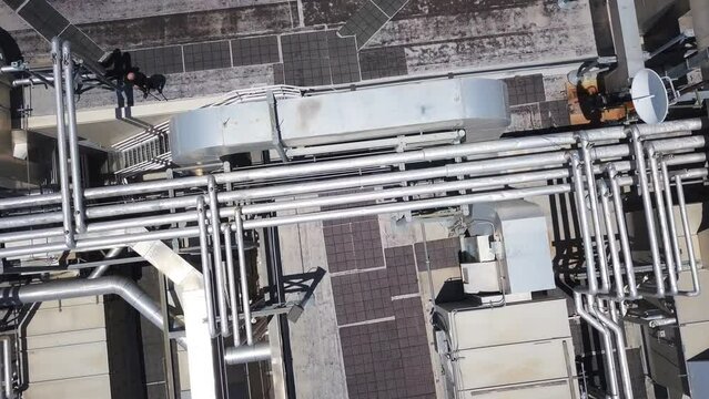 Ascending drone shot of a rooftop with armed guards looking around