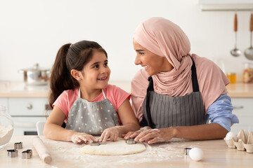 Smiling Muslim Mom With Her Little Daughter Baking Together In Kitchen