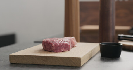 raw ribeye steak on oak wood board