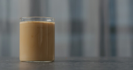 coffee with cream in glass on concrete countertop