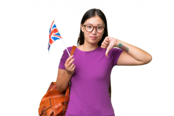Young Asian woman holding an United Kingdom flag over isolated background showing thumb down with negative expression