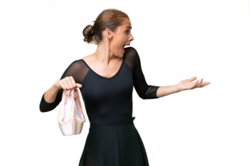 Young caucasian woman practicing ballet over isolated background with surprise expression while looking side