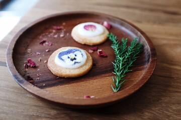 Christmas cookies and tea on a wooden plate with festive decorations surrounded by fresh ingredients and gourmet snacks