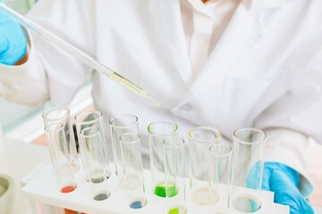 Scientist conducting experiments with tubes and liquids in laboratory