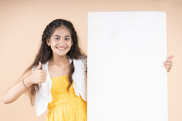 Young girl  holding a blank board with thumbs up