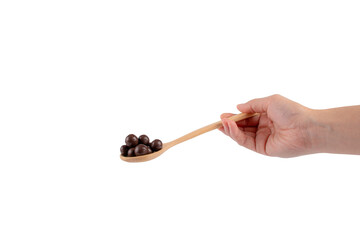 Hand and chocolate balls on wooden spoon on transparent background.