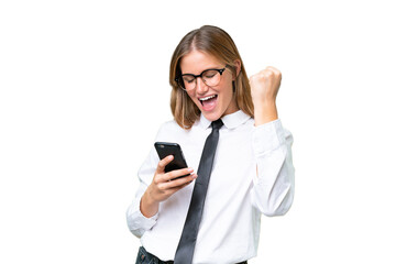 Fototapeta premium Young business caucasian woman over isolated background with phone in victory position