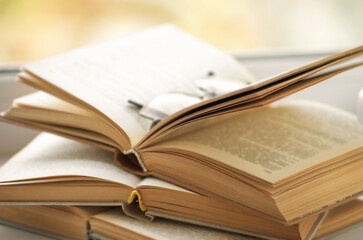 Open book on a window sill, illuminated by sunlight.